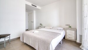 Una camera da letto con un letto, comodini, una sedia e una porta.