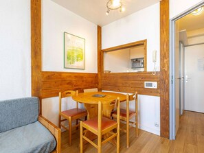 A wooden-framed room with a dining table, chairs, a sofa, a framed picture, a microwave, and a telephone. - Bright apartment with open view - 5 guests (Avoriaz)