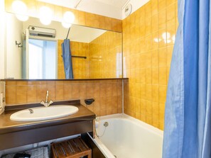 A bathroom with a sink, mirror, and bathtub. - Cozy apartment with ski locker - 5 guests (Avoriaz)