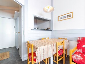 A compact kitchen with a dining table, chairs, a hanging light fixture, and a framed photo on the wall. - Cozy apartment with ski locker - 5 guests (Avoriaz)