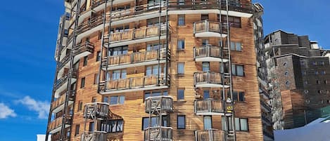 Ein mehrstöckiges Gebäude mit Holzverkleidung und Balkonen.