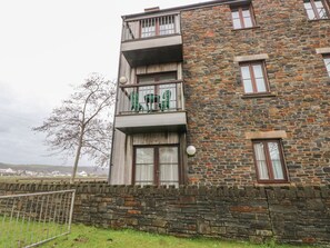 A multi-story building with a stone facade, balconies, and windows. - 2 Chandlers Yard, Burry Port (Burry Port)