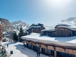 A snow-covered mountain town with buildings, including a wooden structure with a sloped roof, and a clear view of the surrounding mountains. - Peaceful studio near shops - 4 guests (Avoriaz)