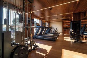 Ein Fitnessstudio mit Laufbändern, Kraftgeräten und einem Rudergerät.