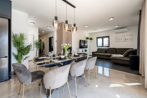 Un comedor moderno con una mesa grande, sillas e iluminación colgante.