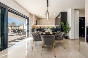 Una cocina moderna con comedor, ventanas amplias y vistas al exterior.