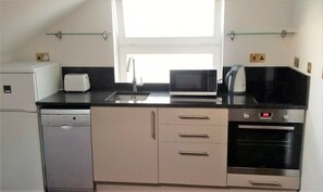 A compact kitchen with a dishwasher, microwave, toaster, and oven. - Peaceful 1-bedroom apartment in welcoming London neighborhood (London)