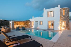 A modern villa with a swimming pool, stone walls, and a bar area. - Mykonos Cloud White Villa (Mykonos)
