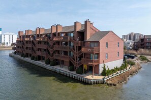A waterfront hotel with multiple balconies, a dock, and a clear view of the water. - Sunset Landing, peaceful water views and front-row seats to some of Ocean City’s stunning sunset (Ocean City)