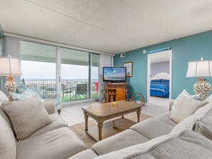Ein Hotelzimmer mit Balkon, Fernseher, Bett und einer Sitzecke mit Couchtisch.