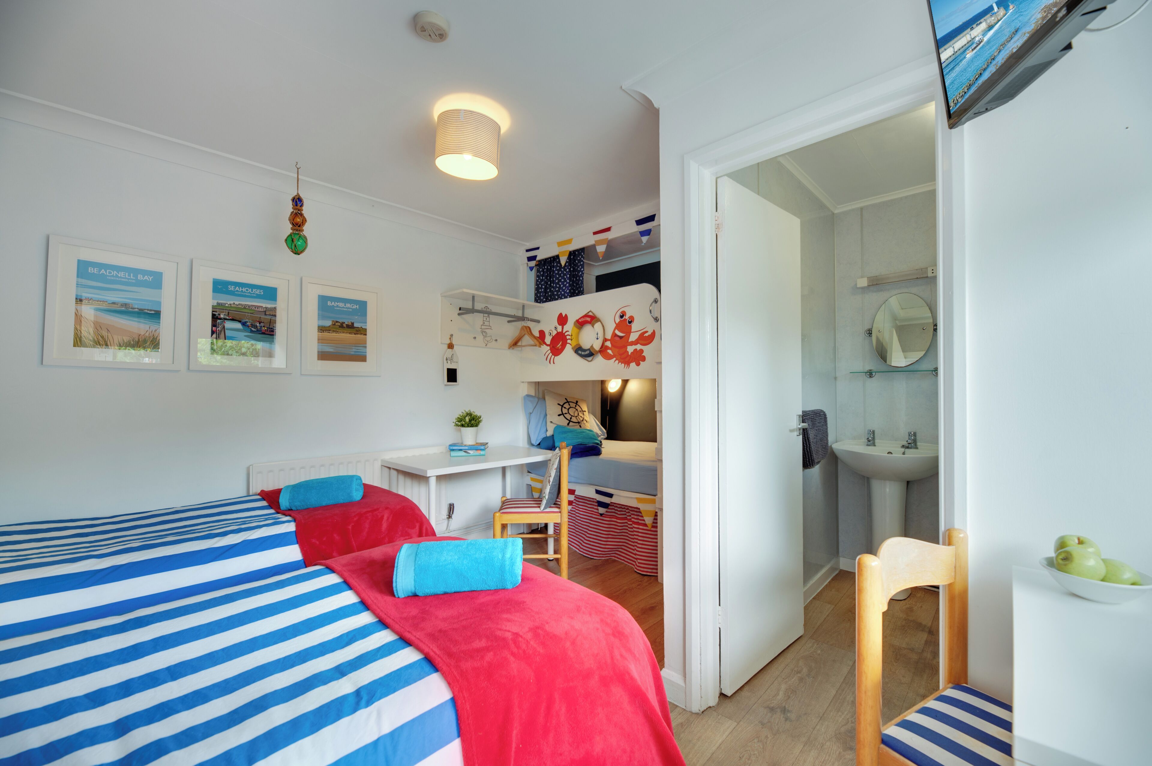 Een slaapkamer met een bed, een bureau, een stoel, een spiegel en een badkamer.