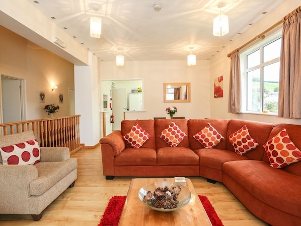 Una sala de estar con un conjunto de sofá, una mesa de centro y una escalera de madera.