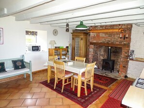 A dining area with a brick fireplace, wooden furniture, and a tiled floor. - The Lookout, Berwick-Upon-Tweed (Berwick-upon-Tweed)