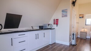 A modern kitchen with white cabinets, a black countertop, and a built-in oven. - Cabin 2 Min Larach (Gortahork)