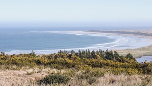 A coastal landscape with a beach, vegetation, and a clear sky. - Cabin 1 Machaire Rabhartaigh (Gortahork)