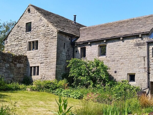 A stone building with multiple windows and a sloped roof.