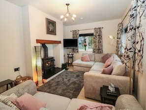 A living room with a fireplace, sofa, and television.