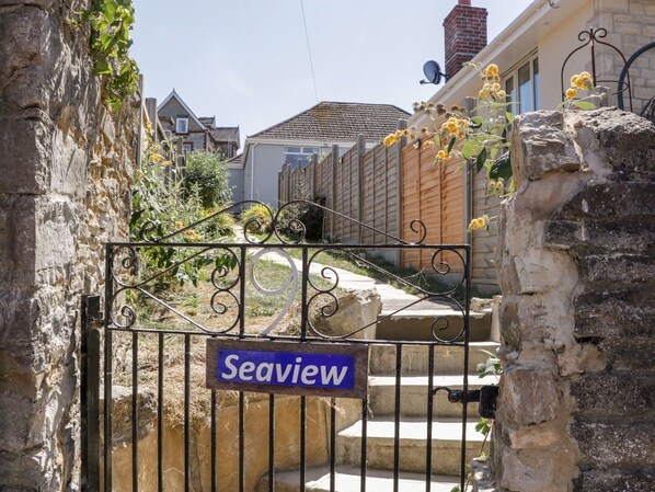 A gated entrance with a 'Seaview' sign, stone walls, and a wooden fence.