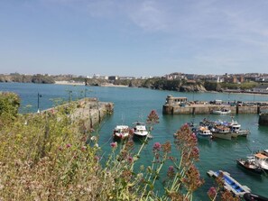 A harbor with boats docked, a pier, and a coastal town in the background. - Flat 4, Newquay, Cornwall (Newquay)