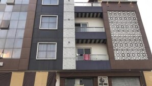 Un edificio de varios pisos con balcones, ventanas grandes y una fachada decorada.