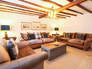 Ein gemütliches Wohnzimmer mit zwei Sofas, einem Couchtisch und einer Chandelier.