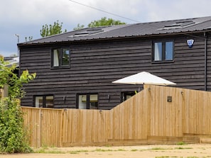 A two-story wooden house with a fenced backyard, a visible window, and a blue badge on the roof. - The Old Dairy, Adiham, near Wingham, Kent. (Canterbury)