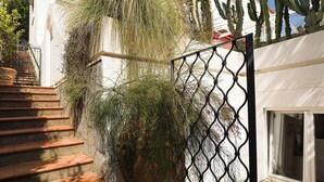 A staircase leading to a white building with a metal gate and a window. - Villa Luna Rossa, Capri (Capri)