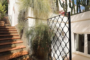 A staircase leading to a white building with a metal gate and a window. - Villa Luna Rossa, Capri (Capri)