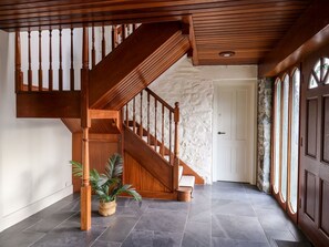 A wooden staircase leading to a landing, a stone wall, and a door with a window. - Dant Y Llew, Bow Street, Wales (Bow Street)
