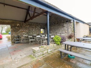 A stone building with a covered patio, outdoor seating, and a picnic table. - The Loft at The Old Dog Thorpe (Ashbourne)