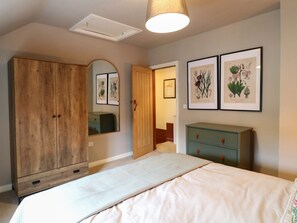 A bedroom with a bed, a wardrobe, a dresser, and framed botanical prints on the wall. - The Loft at The Old Dog Thorpe (Ashbourne)