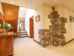 A hallway with a wooden desk, a stone wall, and a staircase. - Glen View Dunscore nr Dumfries (Dumfries)