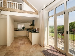 A spacious kitchen with a large island, a dining area, and a view of the outdoors. - The Hayloft, Honiton (Honiton)