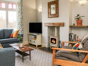 A living room with a sofa, a coffee table, a television, a fireplace, and a bookshelf. - Willow View, Shrewsbury (Shrewsbury)
