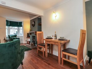 A dining area with a wooden table, chairs, and a fireplace. - Kestrel Cottage, in Stokesley. (Middlesbrough)