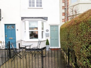 A white house with a blue door, a green door, and a window with a view. - Kestrel Cottage, in Stokesley. (Middlesbrough)