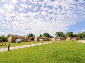 A modern building with a flat roof, large windows, and a grassy lawn. - Chianti, Seaview Retreat in Pondwell (Ryde)