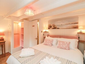 A bedroom with a bed, bedside lamps, a painting, and a walk-in closet. - 98 Westgate is in Guisborough. (Guisborough)