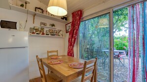 Ein Essbereich mit Holztisch, Stühlen und einem Kühlschrank.