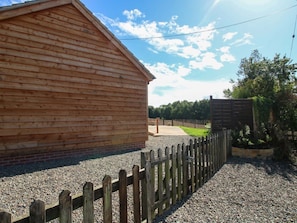 Un bâtiment en bois avec une allée en gravier et une clôture en bois.