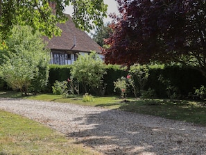 A house with a gravel driveway, surrounded by greenery and a large tree with red leaves. - The Old Stables, Headcorn (Ashford)