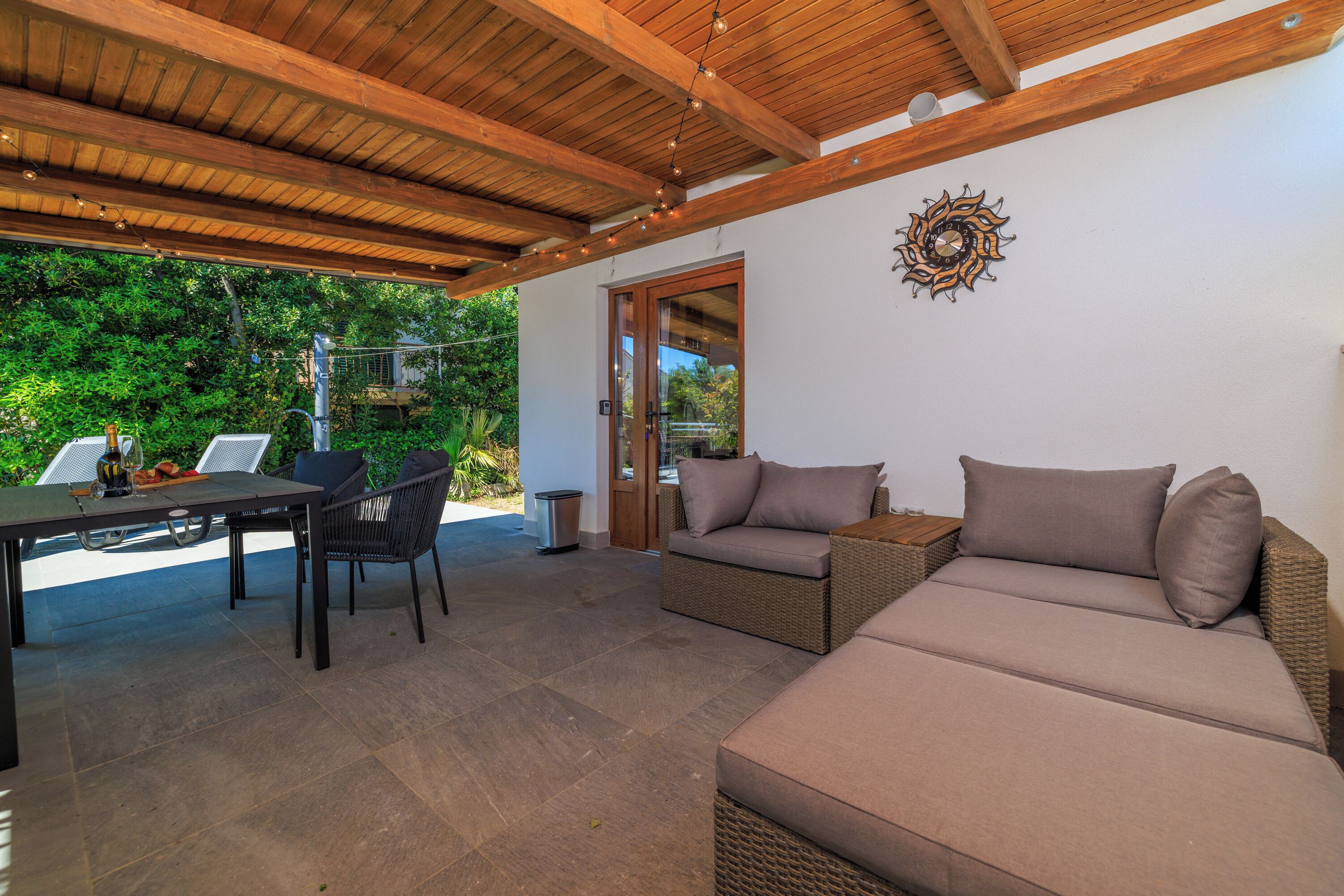 An outdoor patio with a table, chairs, and a sofa.