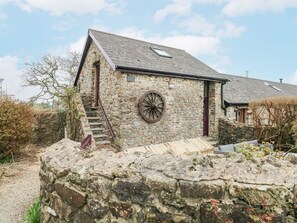 A stone building with a wheel, a staircase, and a small window. - Coach House, near Broad Haven. (Haverfordwest)