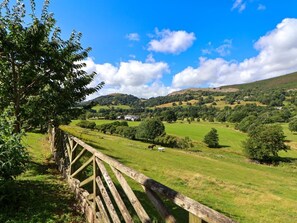 A rural landscape with a wooden fence, rolling hills, and a clear blue sky. - The Willows Denbighshire 4-bed (Llangollen)
