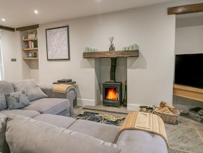A living room with a sofa, a fireplace, a television, and a map on the wall. - Howgill House, Sedbergh, Wi-Fi (Sedbergh)