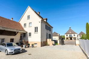 Ein Wohngebäude mit Auffahrt, einem parkenden Auto und blauem Himmel.