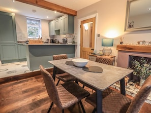 A kitchen with a dining table, chairs, and a fireplace. - West View, Milnthorpe (Milnthorpe)