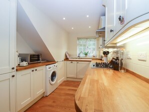 A compact kitchen with a washing machine, a microwave, and a sink. - Spindlewood Cottage, Hawkhurst (Cranbrook)