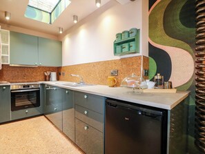Een moderne keuken met een vaatwasser, oven en een opvallend muurdecoratie.