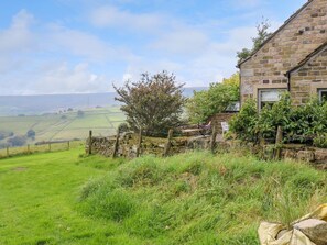 A stone building with a stone wall and a grassy field in the background. - Black House Cottage, Ripponden (Sowerby Bridge)